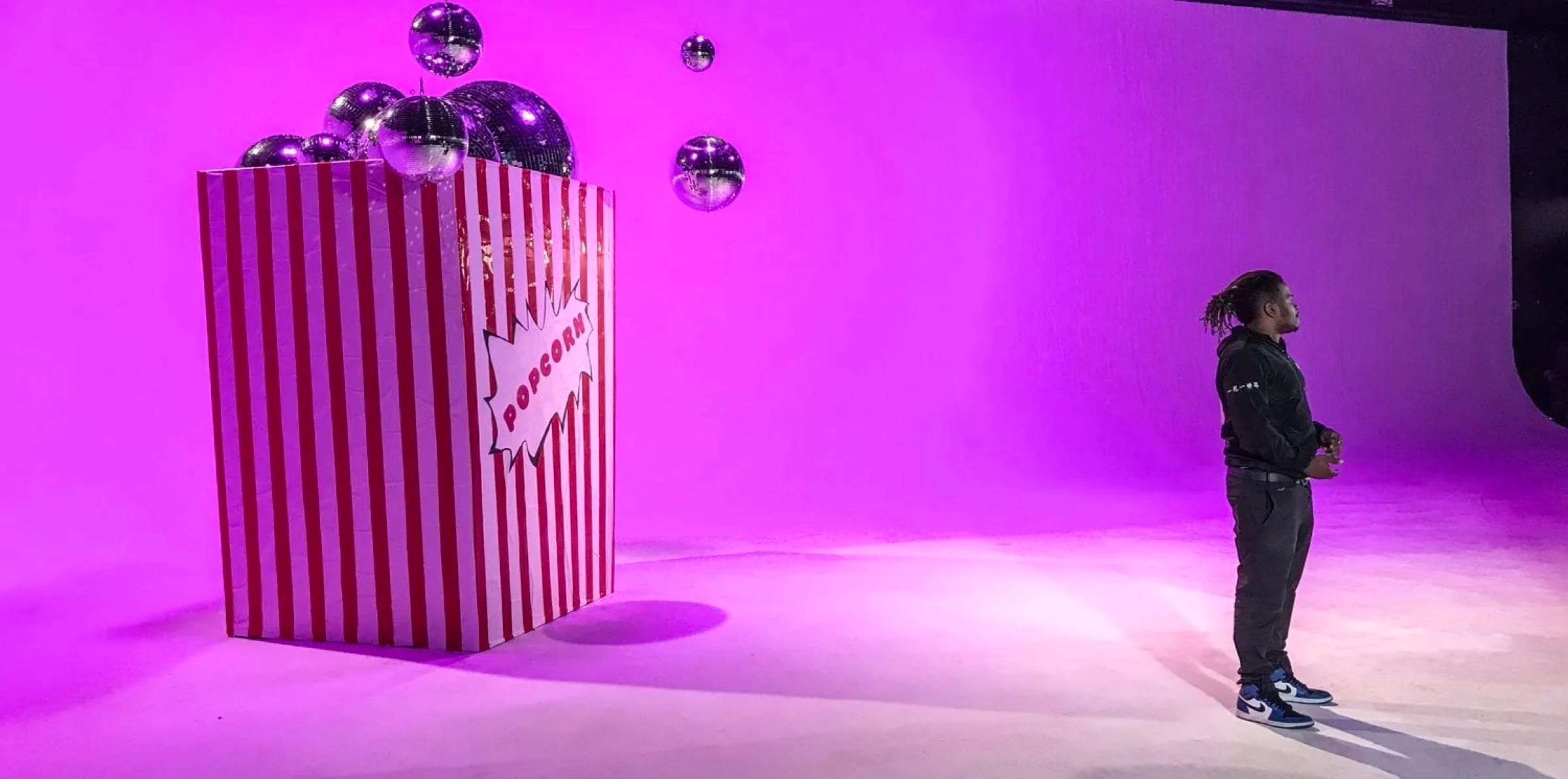 A striped installation in a pink-lit studio
